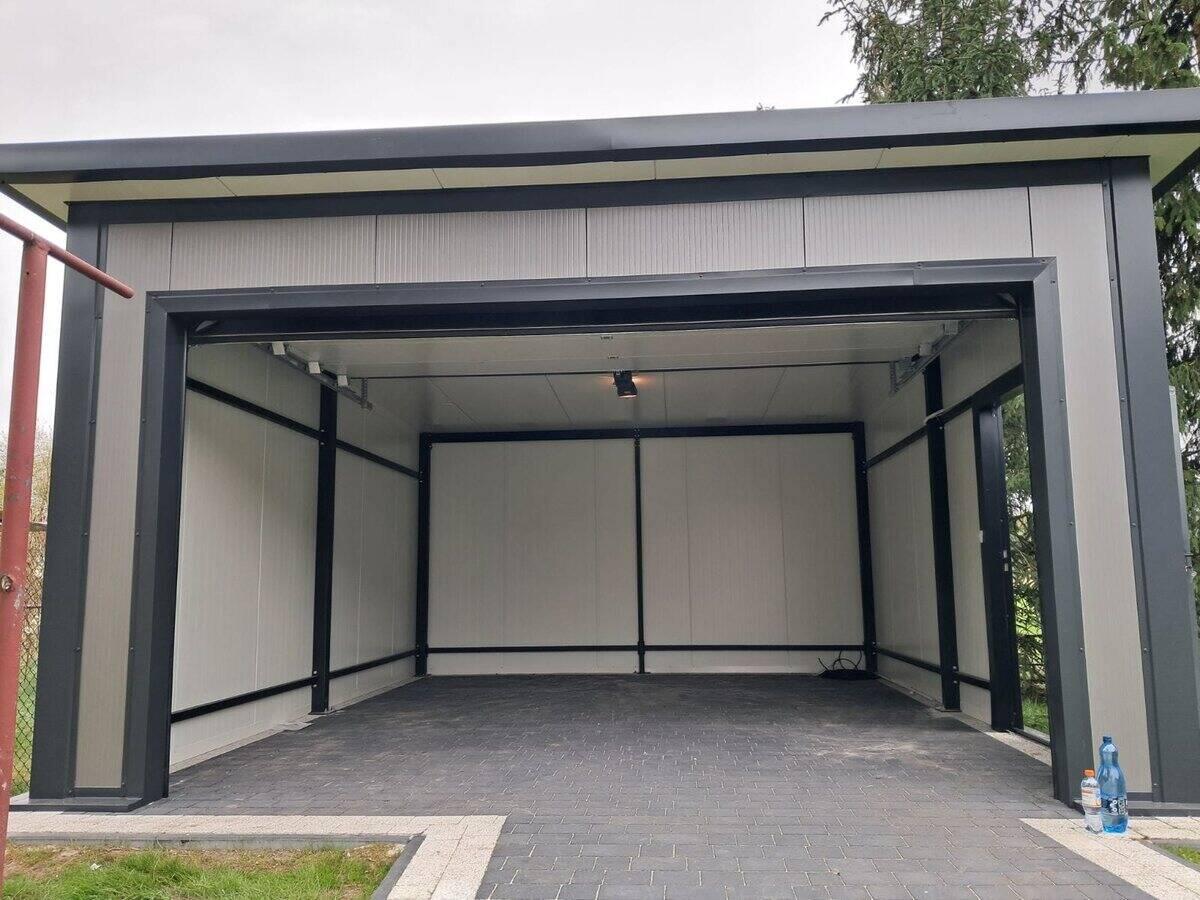 Insulated PIR garage with door open, showing flat roof profile and concrete base on tarmac driveway