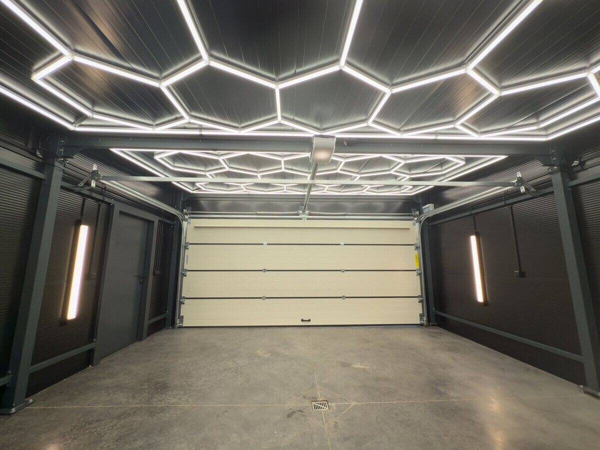 Insulated garage interior with hexagonal LED ceiling lighting and white PIR wall panels