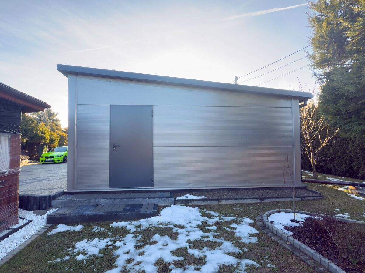 White-walled insulated PIR garage in winter with snow, anthracite sectional door and side window