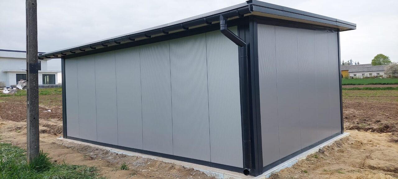 Grey insulated PIR garage, rear three-quarter view showing the large composite wall panels and pent roof