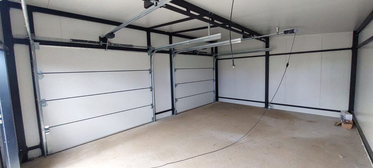 Insulated garage interior with white PIR wall panels, bolted steel frame and two door openings