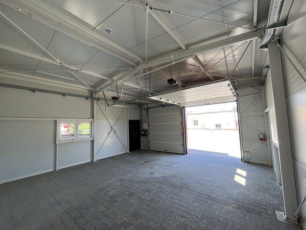 Insulated garage interior looking out through the open sectional door, white PIR panels