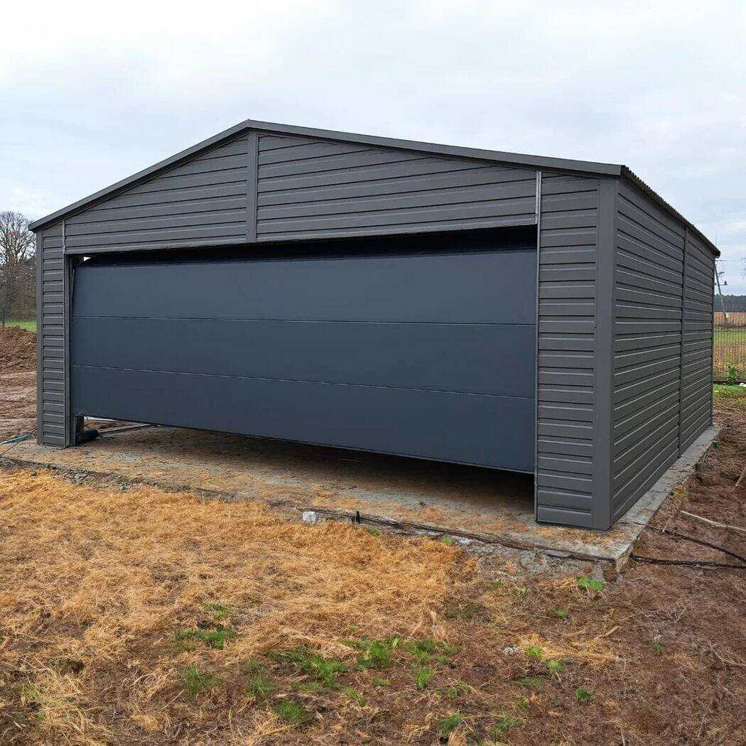 Anthracite steel garage with mono-pitch roof, front three-quarter view on gravel