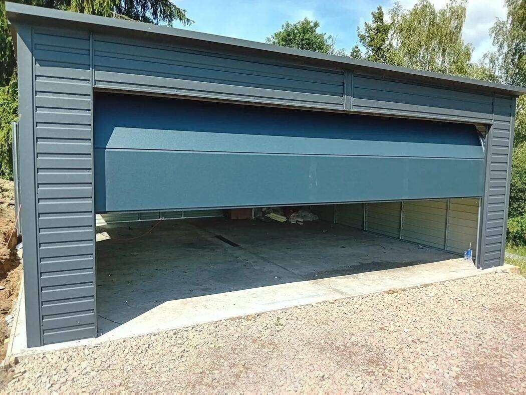 Anthracite steel garage, front-right three-quarter view on block paving
