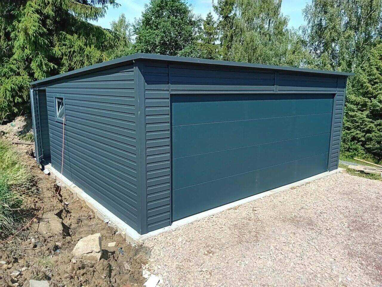 Anthracite steel garage, front-right three-quarter view showing the ribbed side wall and side door