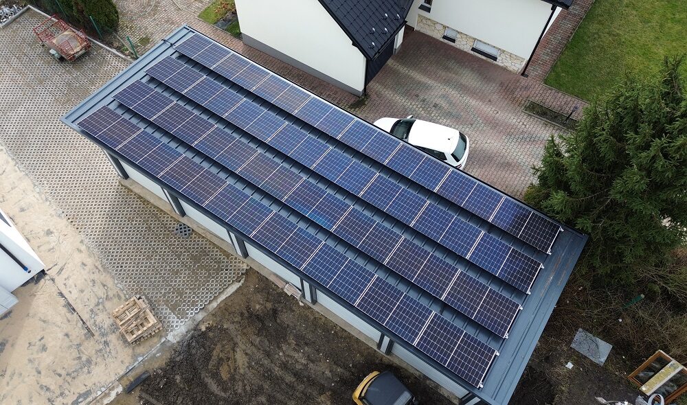 Aerial view of a flat-roof insulated garage with a full solar panel array