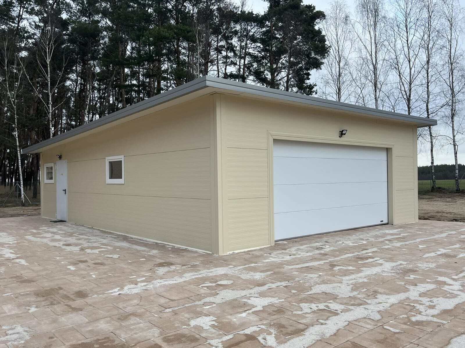 Beige insulated garage, three-quarter view with garden foliage in the foreground