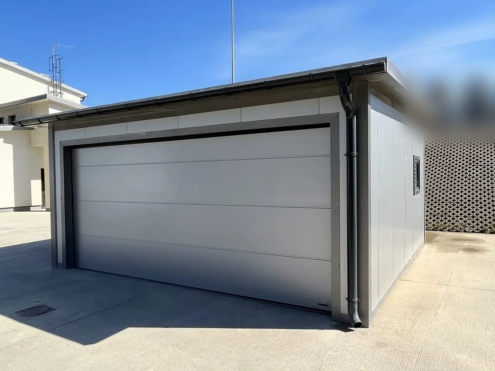 Light grey insulated garage, three-quarter view with the sectional door closed