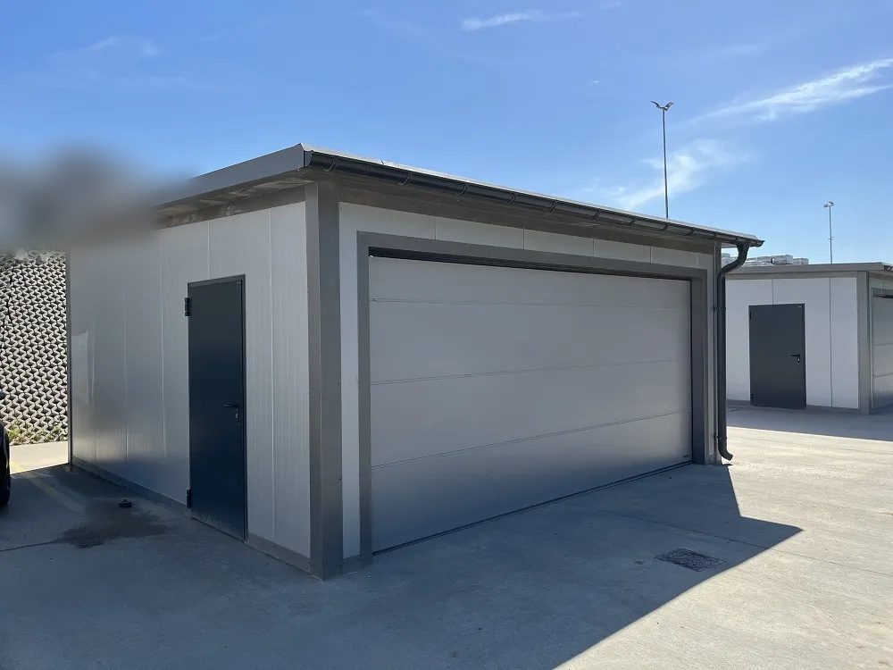 Light grey insulated garage, front three-quarter view with a side personnel door
