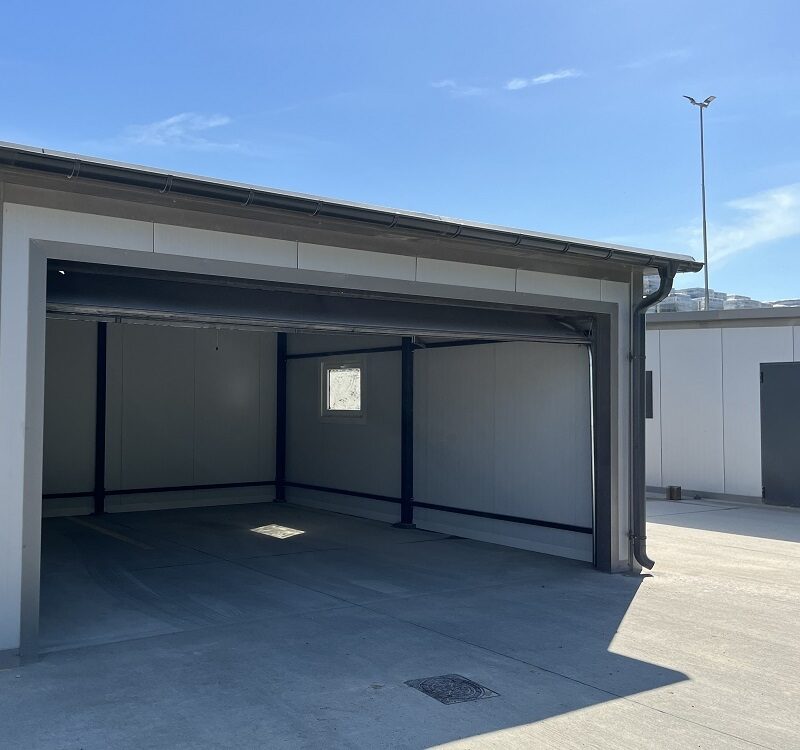 Insulated garage interior seen through the open sectional door, side personnel window visible