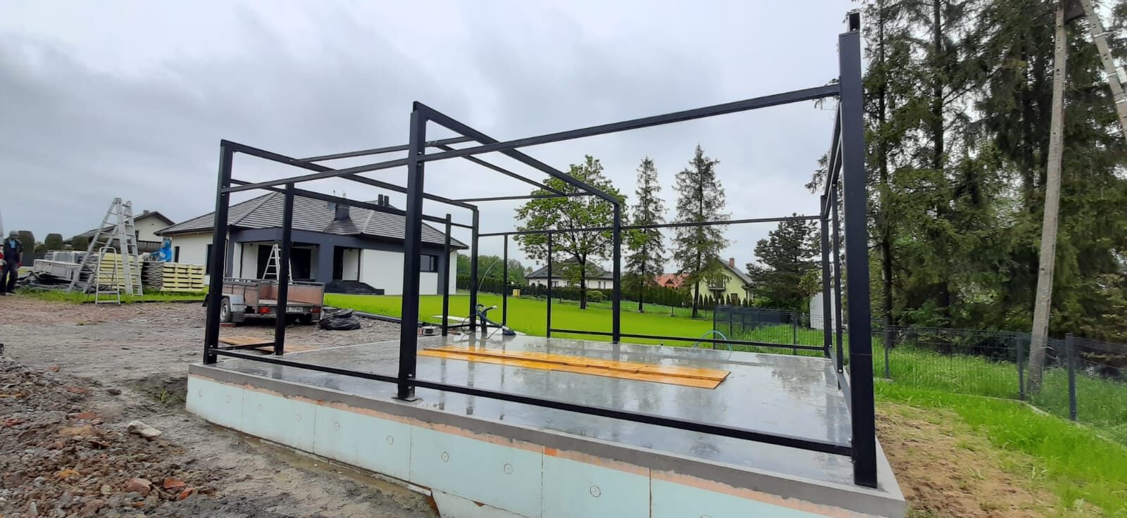 Insulated garage steel frame under construction on its finished base, before the panels go on