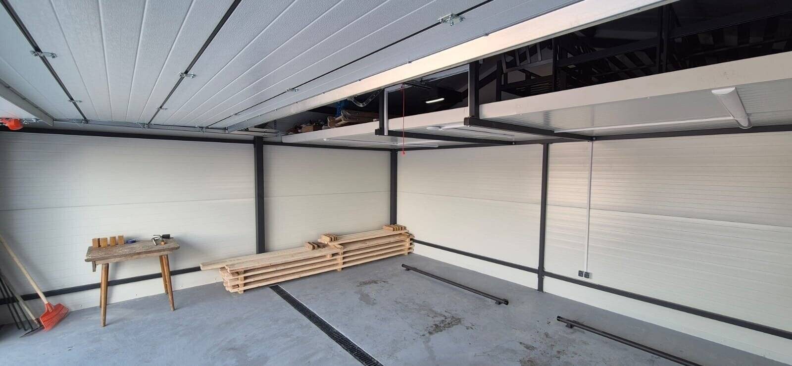 Insulated garage interior with white PIR liner panels and concrete floor