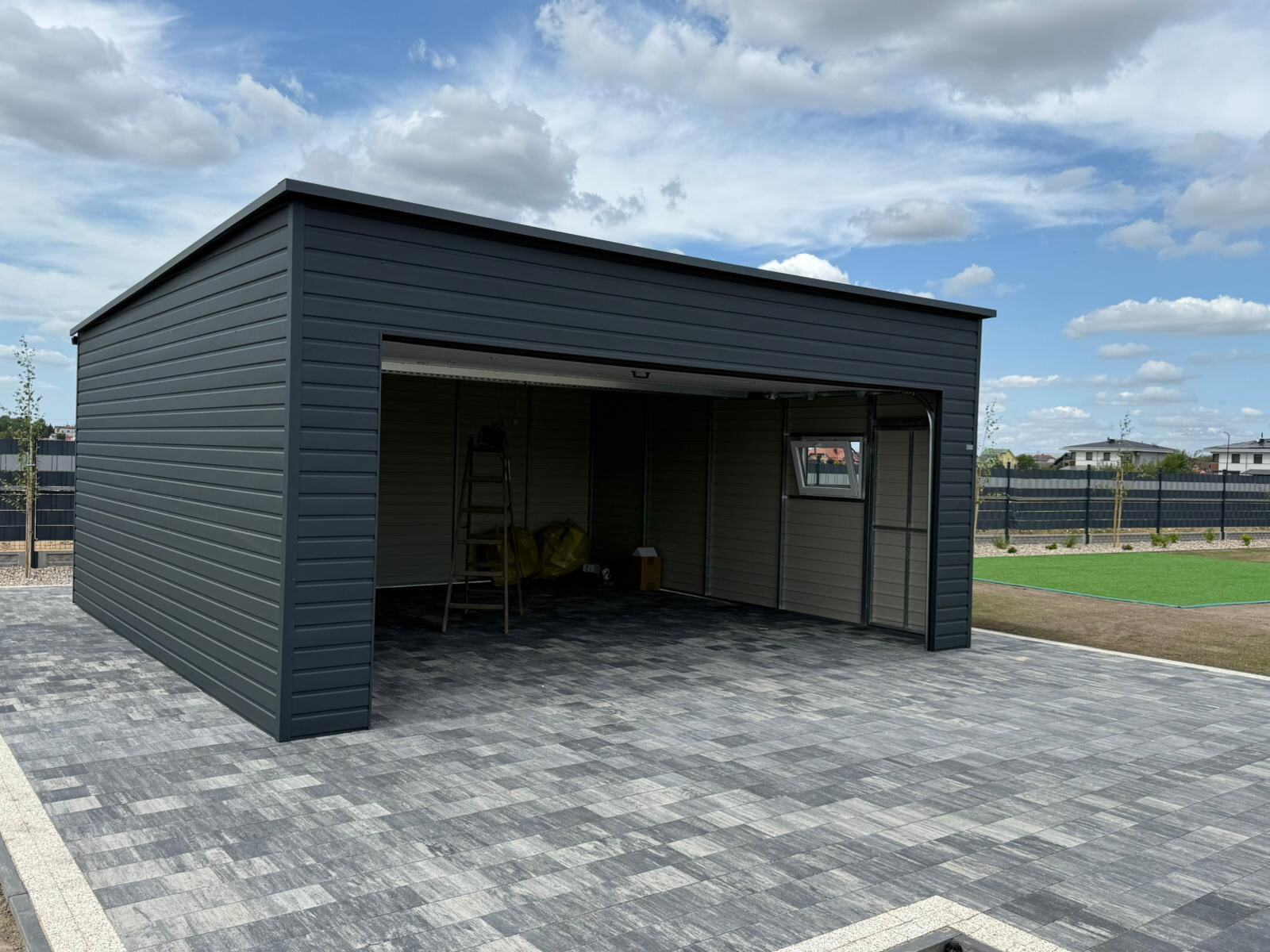 Interior of an anthracite steel garage with the door open, three-quarter view