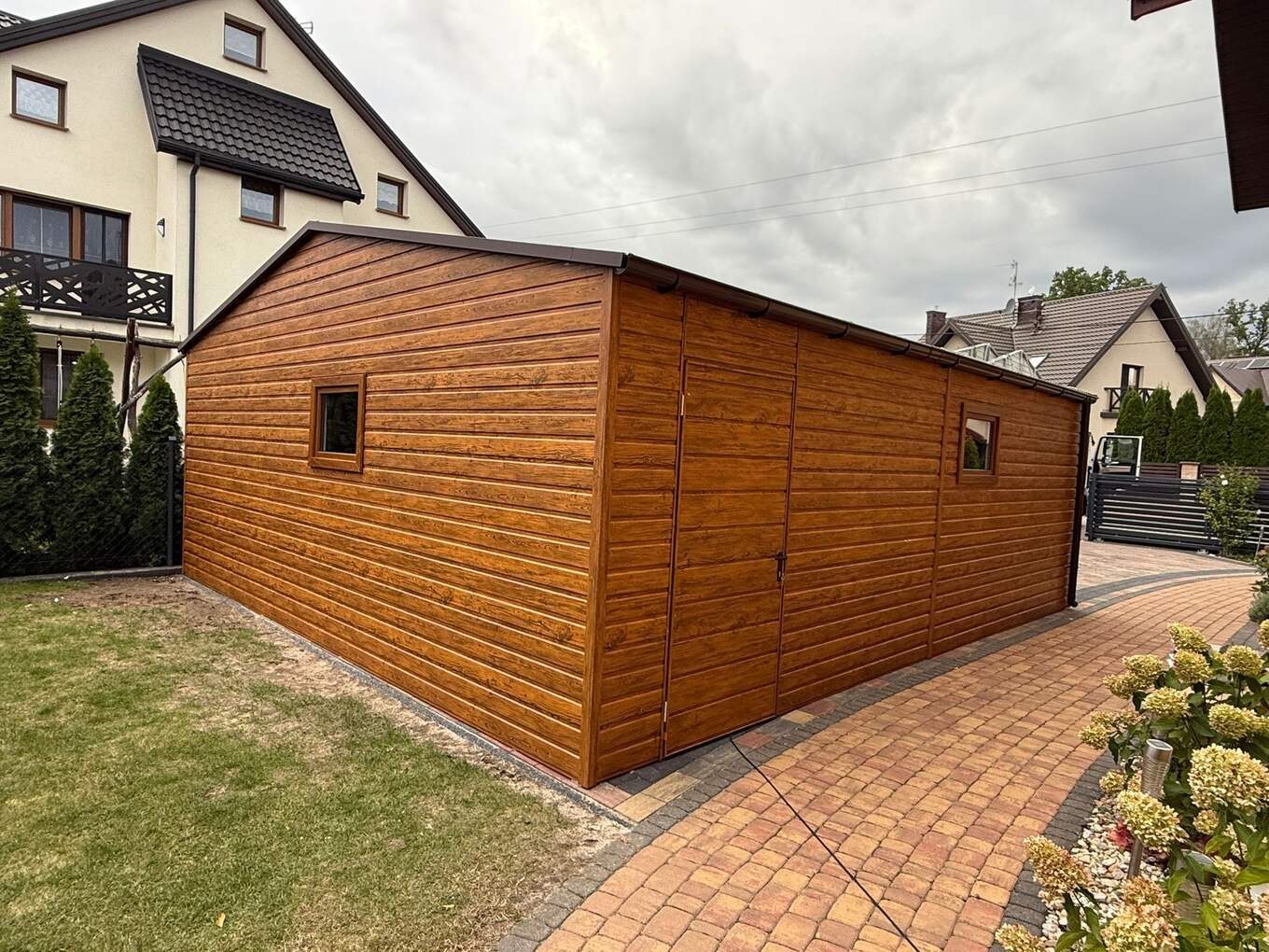 Wood-effect steel garage with hinged double doors, three-quarter view