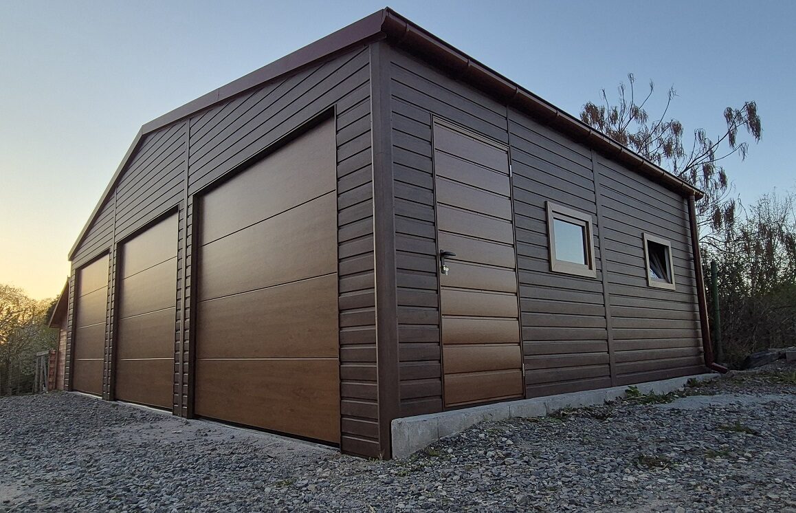 Brown wood-effect steel garage with an apex roof, three sectional doors, a side entrance door and two windows