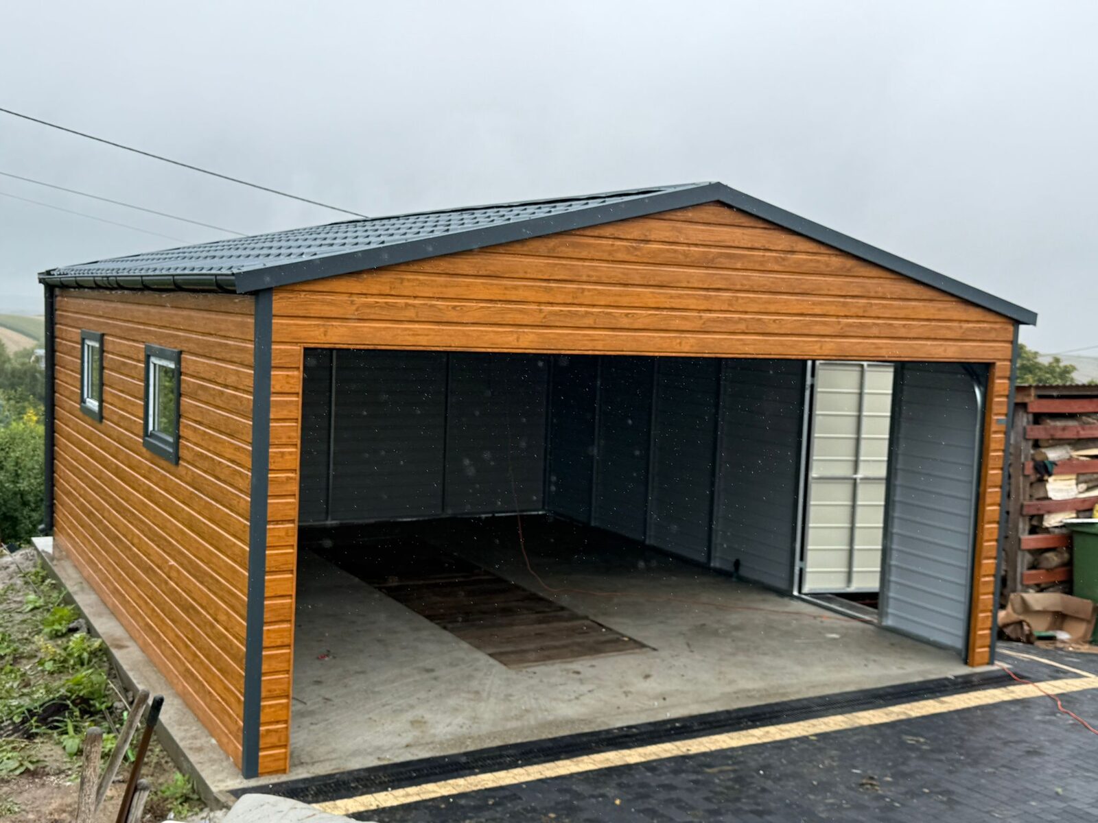 Interior of a wood-effect steel garage with the door open, side window visible