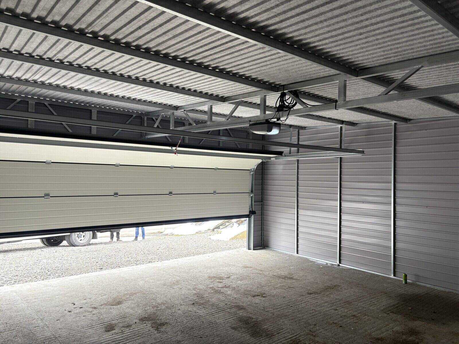 Inside a steel garage looking out through the open sectional door