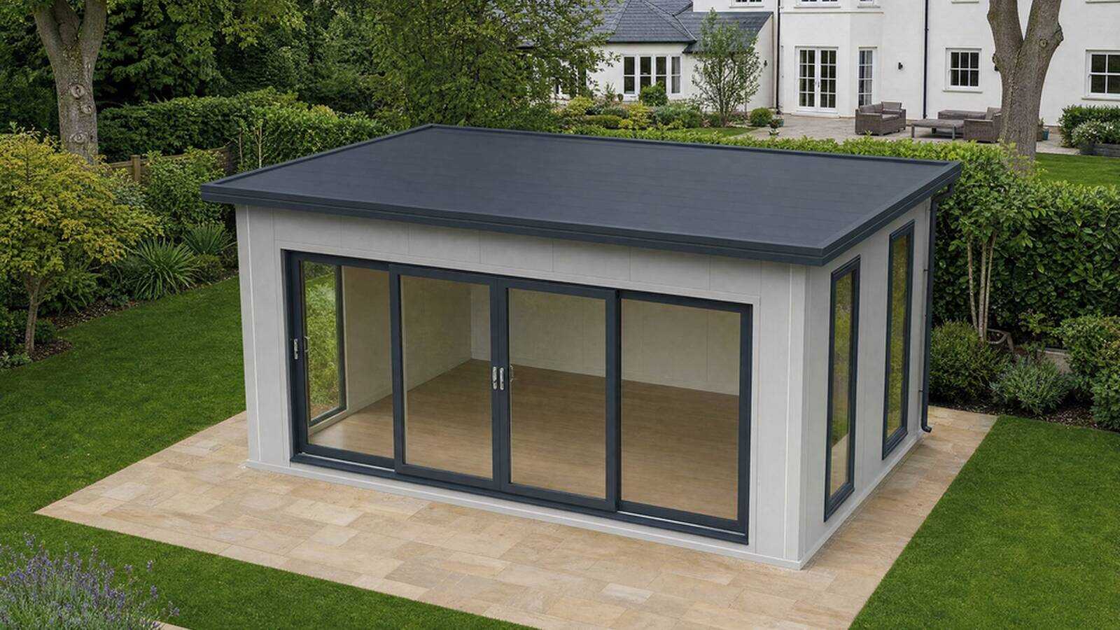 VeltHaven glazed garden room with anthracite frame and sliding glass front in a landscaped British garden