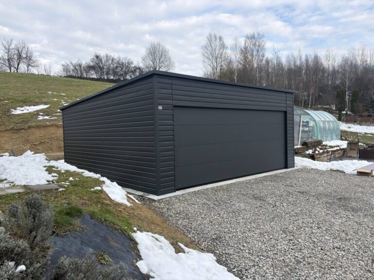 Anthracite steel garage installed on a prepared base beside a British home