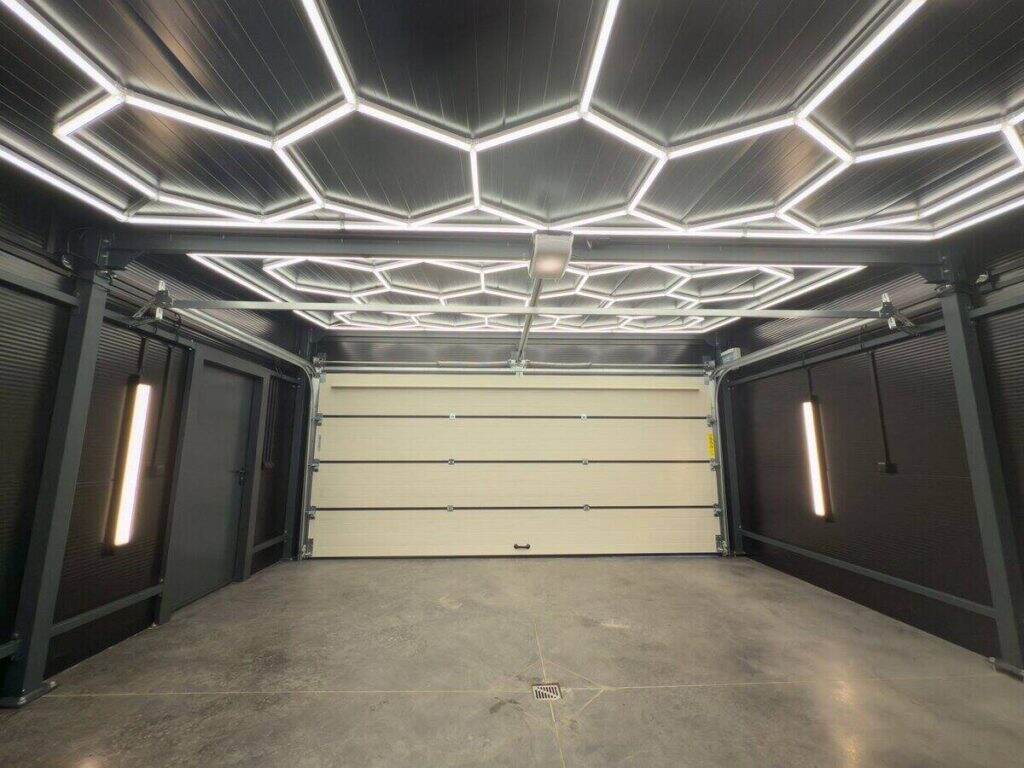 Insulated garage interior with hexagonal LED ceiling lighting and white PIR wall panels